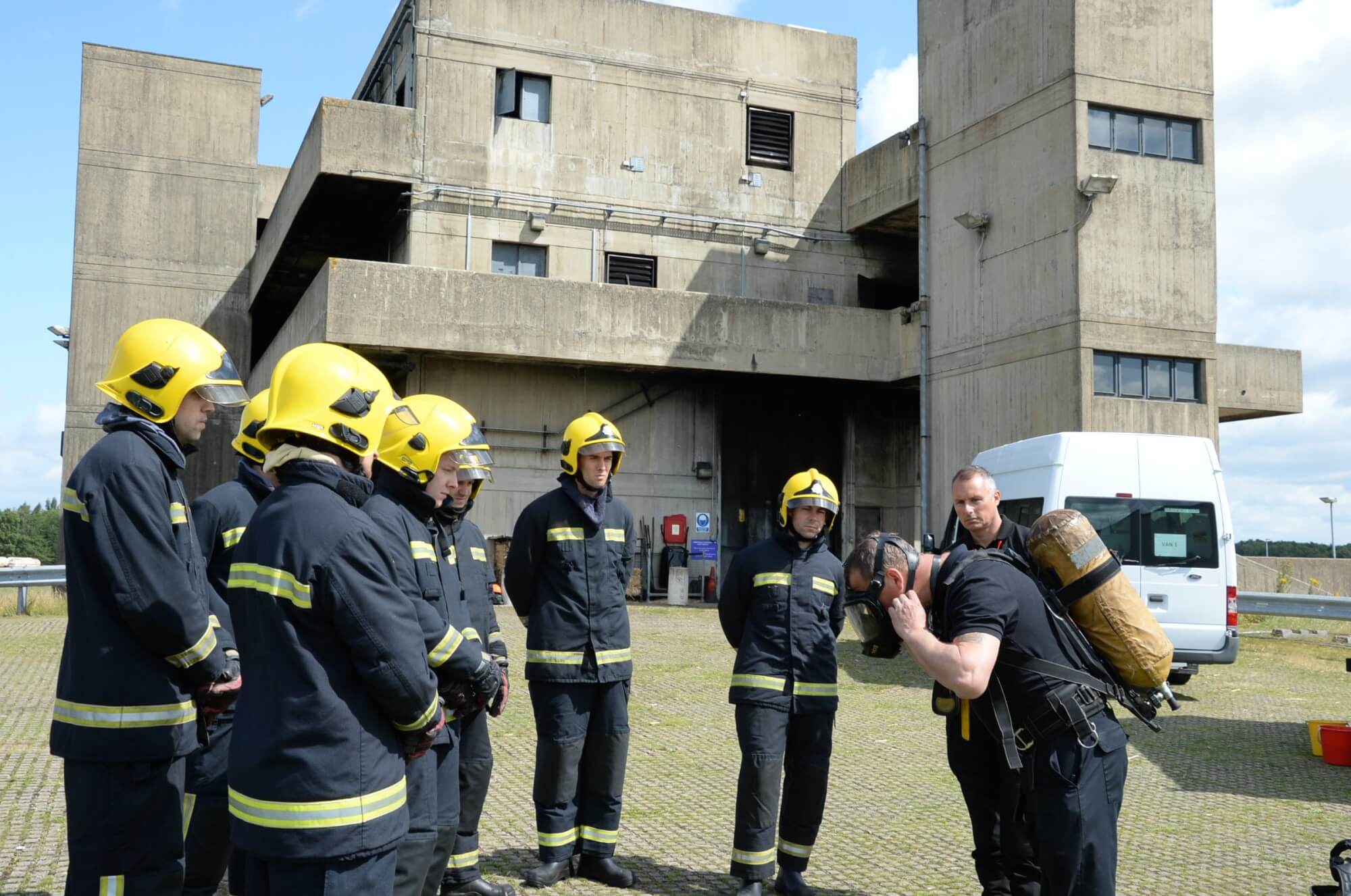 Firefighter trainees watching instructor in breathing apparatus