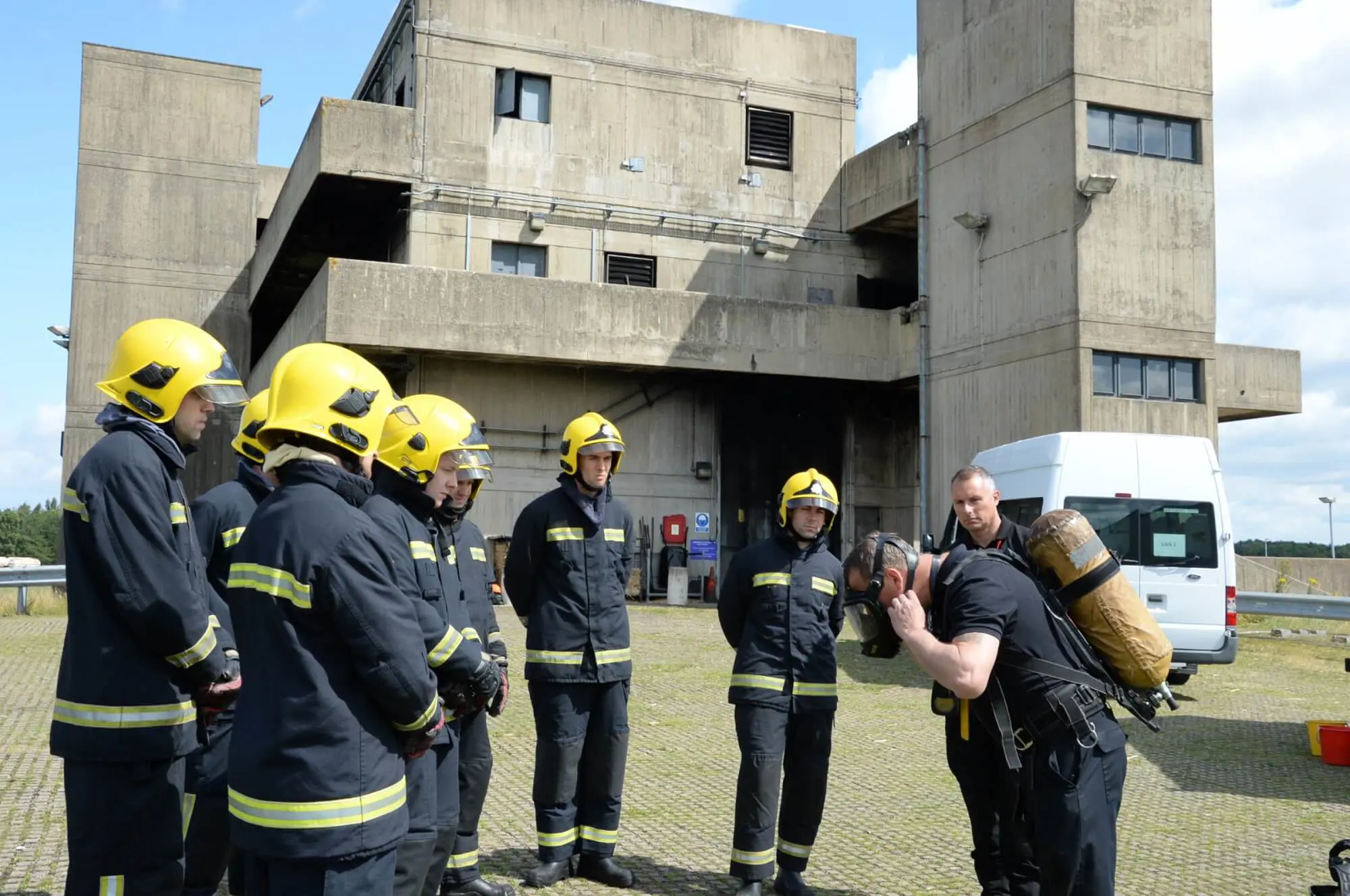 Firefighter trainees watching instructor in breathing apparatus