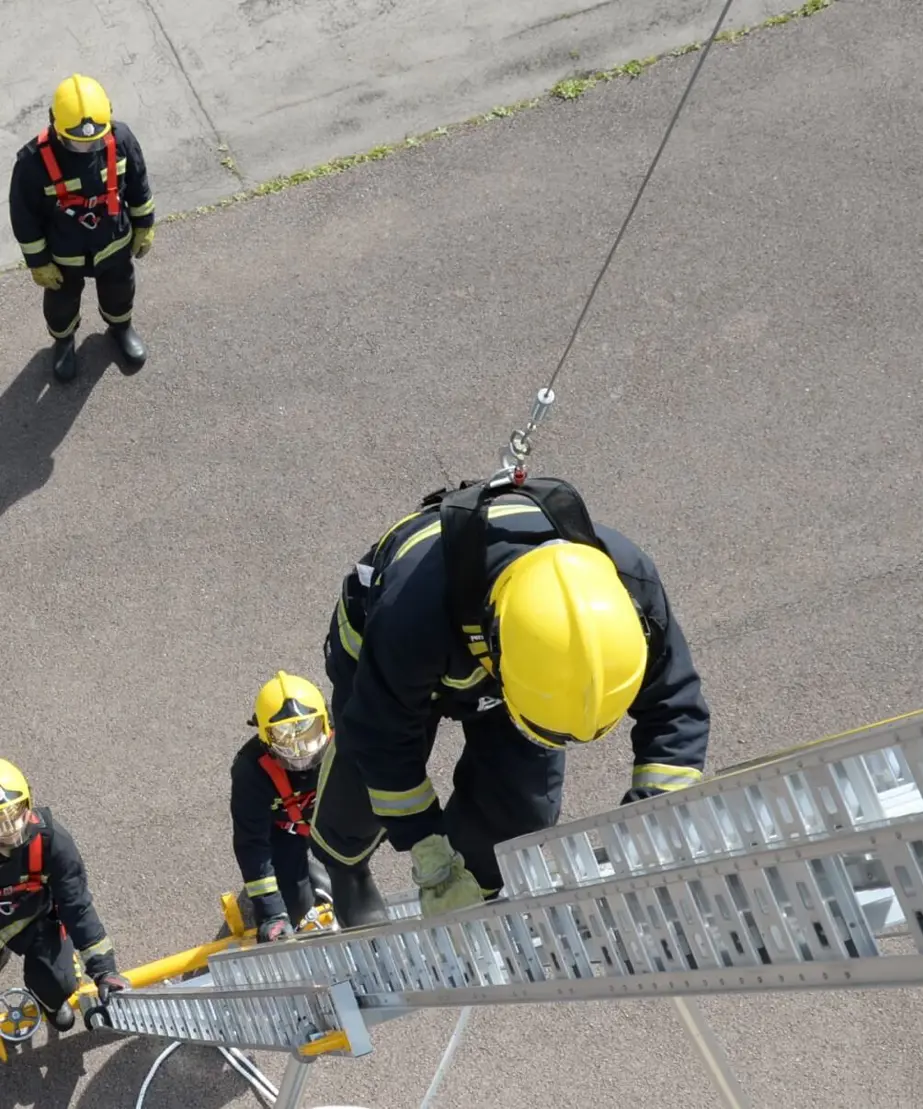 Harness training group with trainee up a ladder
