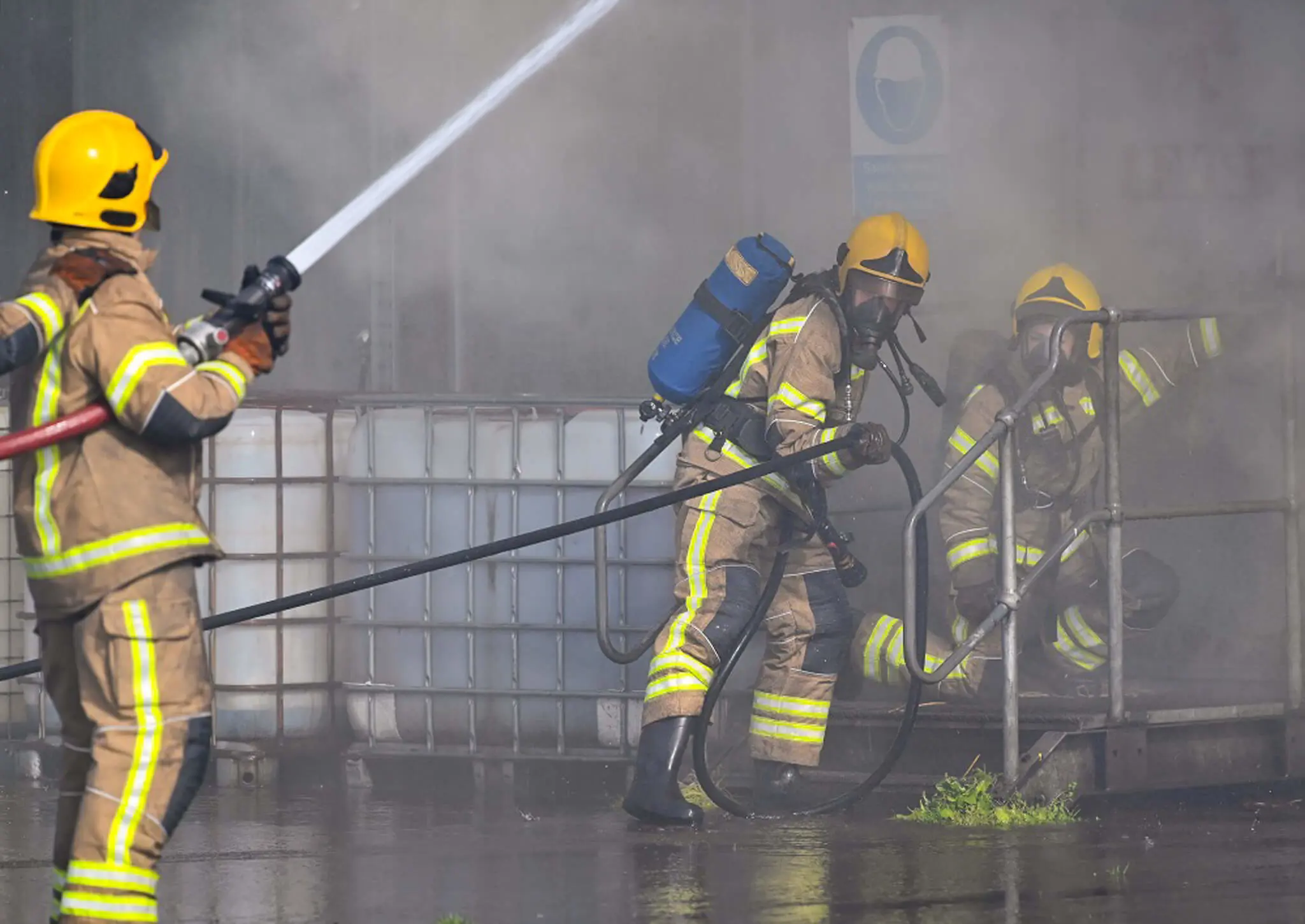 Firefighters in training with fire hose