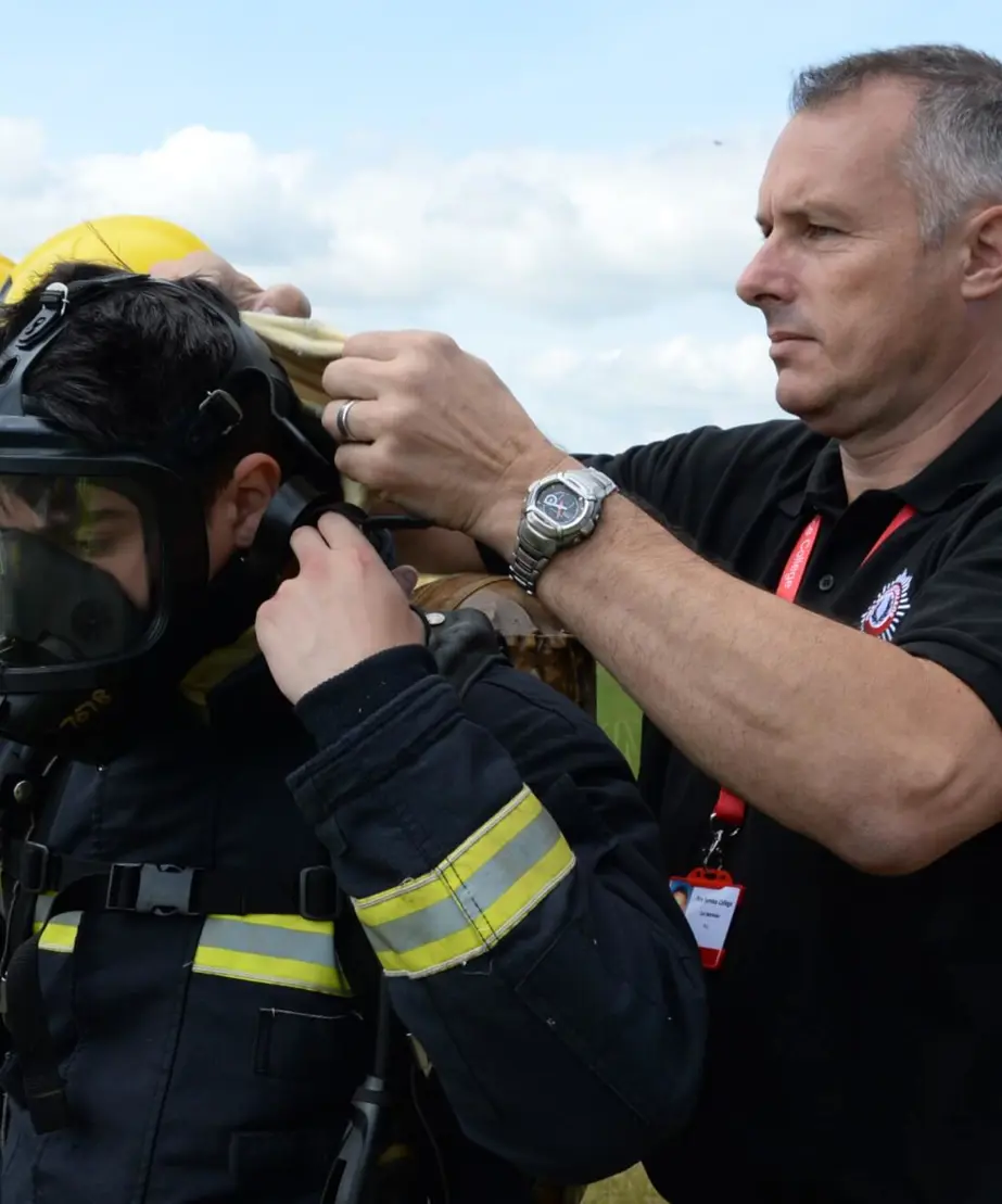 Instructor fitting trainee with breathing apparatus